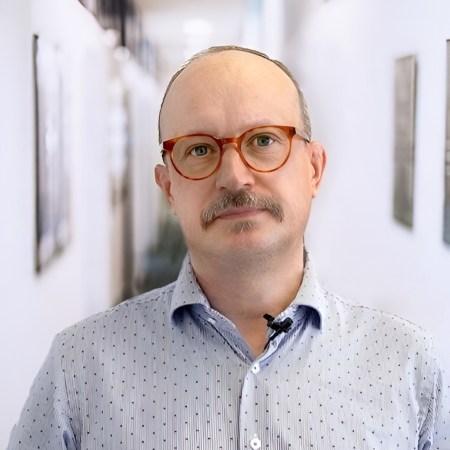 Picture of man looking into the camera, wearing glasses and a shirt. The main is the Administration Director, Dr Daniel Eriksson.